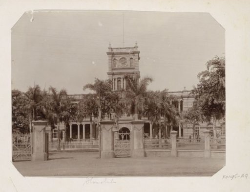 Government building Aliiolani Hale with palms and the statue of King Kamehameha I in Honolulu