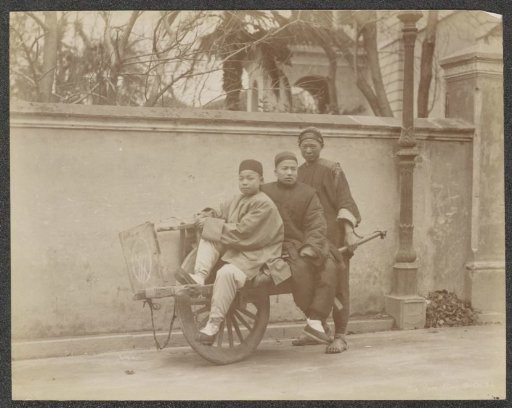 Three Chinese men in Shanghai using wheelbarrows as a means of transport