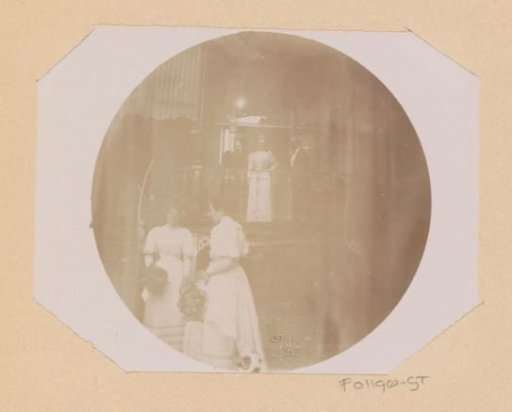 Cato Piek-Asser, standing at the top of an outside staircase next to her mother and an unknown man during her wedding, at the bottom of the staircase stands Gesiena Piek with an unknown woman and child