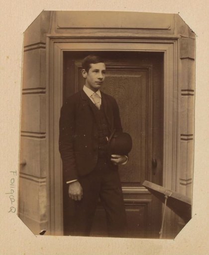 Portrait of an unknown young man with a bowler hat by a door