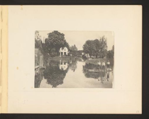 View of a house reflected in a canal, three boys with clogs on the right