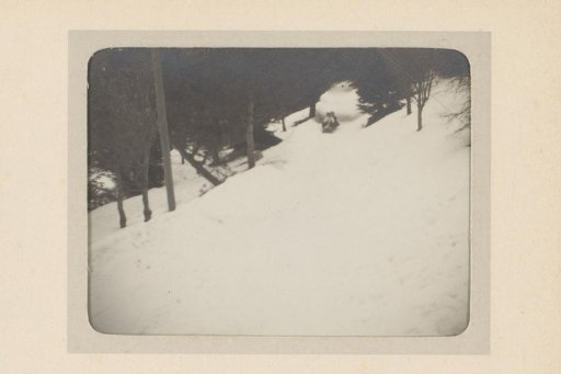 Two People Sliding Down a Snowy Slope on a Bobsled