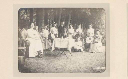 Group portrait of a company around a table in the woods at Ellecom