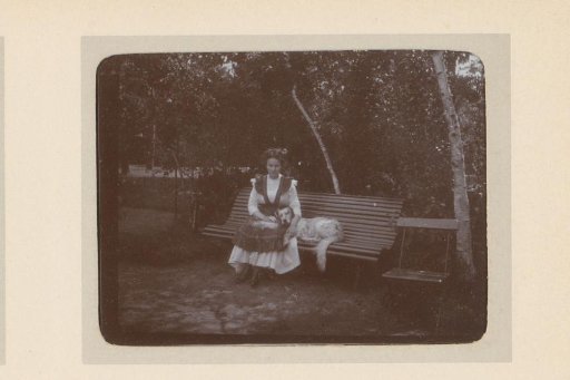 Portrait of a woman sitting on a bench with a dog in a garden