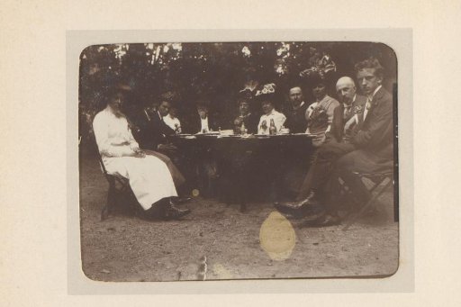 Group portrait of a company around a table in the woods