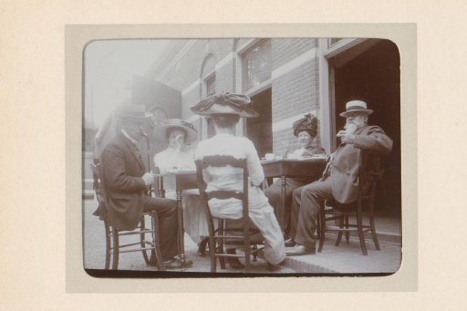 Group portrait of a company around a table in front of a facade