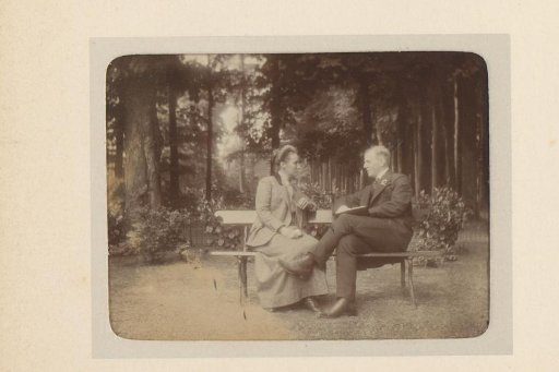 Man and woman in conversation on a bench in a garden or park