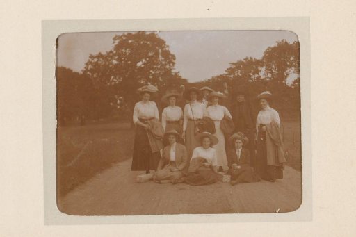 Group portrait of ten young women on a sandy path