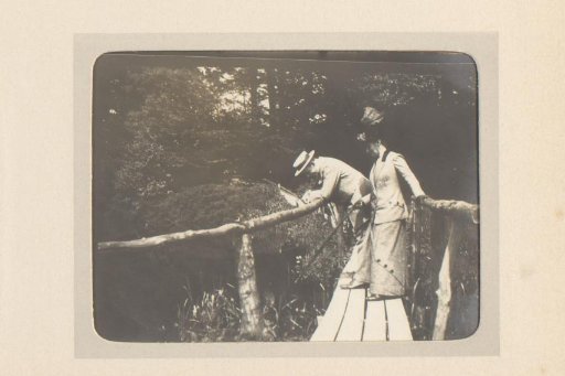 Man and woman on a wooden footbridge over a stream