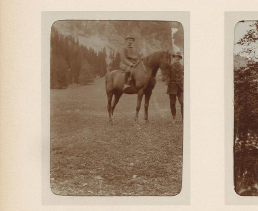 Man on horseback and a man beside him on a mountain meadow