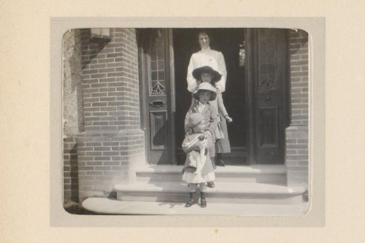 Portrait of a Woman, Three Children, and a Cat on a Porch in Front of a Front Door
