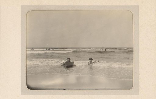 Two women lying in the surf