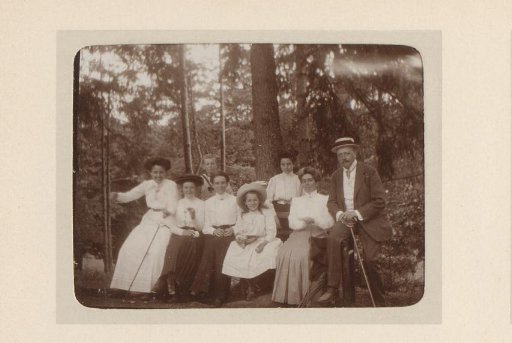 Group portrait of five women, a man and two children in a forest
