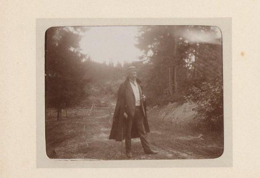 Portrait of a man with a cigar and overcoat in a mountain meadow