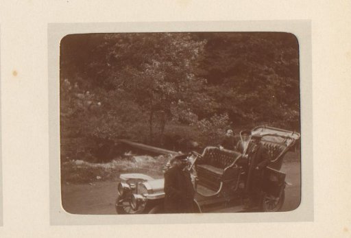 Two men, a woman and a child by a car