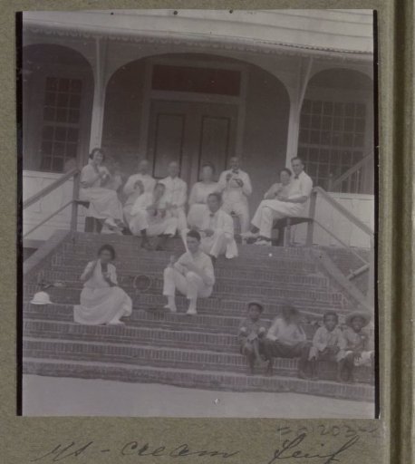 Group portrait of a group sitting on steps at a tennis court in Suriname