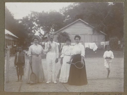 Group with tennis rackets on a tennis court in Suriname