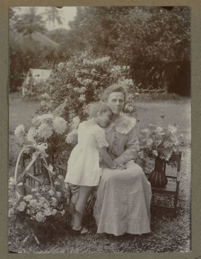 Seated woman with a child in a garden in the Dutch East Indies