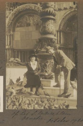 Man and woman among the pigeons on St. Mark's Square in Venice
