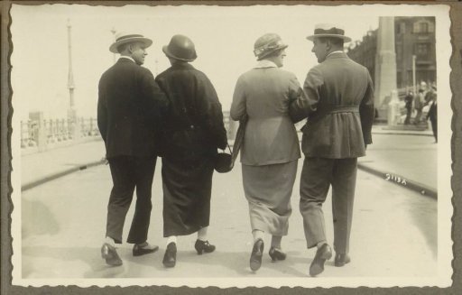 Two men and two women walking on the boulevard of Scheveningen, seen from behind