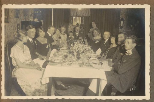 Group at a set table on a festive occasion, possibly in the Netherlands