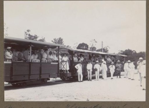 Governor Aarnoud van Heemstra (standing in a dark suit) with a group at train carriages on the way to the Maäboberg in Suriname