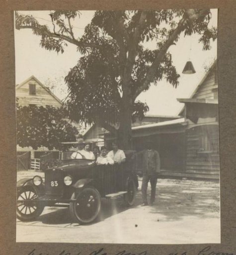 Group in a car under a mango tree in Suriname