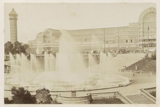 Exterior of the Crystal Palace in London, with a fountain in the foreground, a water tower on the left