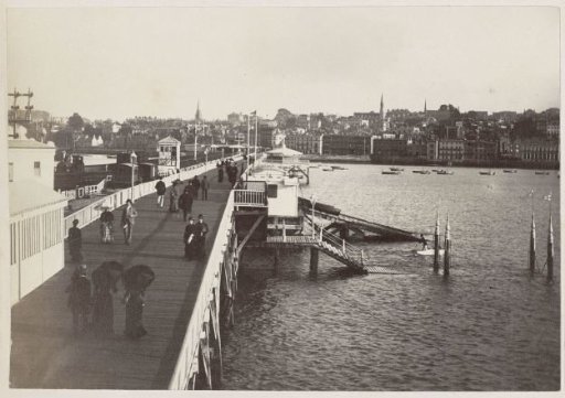 Walkers on Ryde Pier, with the town of Ryde on the Isle of Wight in the background