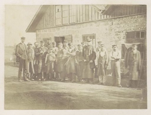 Group Portrait of Workers in Front of a Workshop