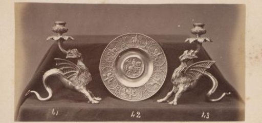 Metal candlesticks in the form of griffins and a plate