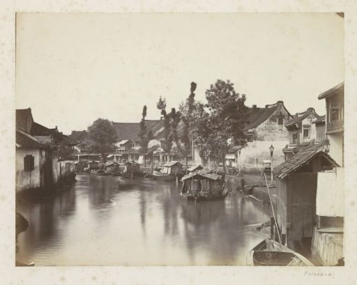 View of a river quay with houses and boats in Java