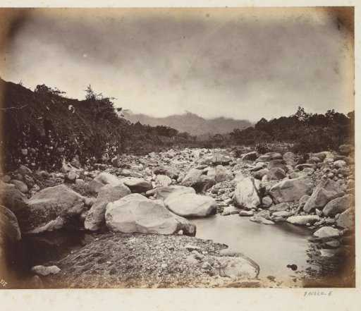 Man sitting on stones in a riverbed in Java
