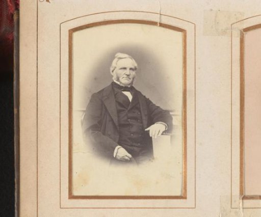 Portrait of a seated man with a ring beard