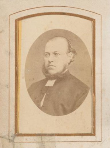 Portrait of a man with a chin curtain beard and spectacles
