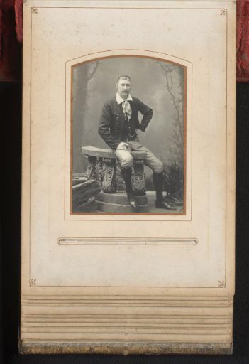 Portrait of a man seated on a balustrade