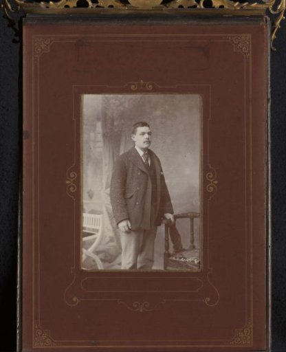 Portrait of a Man with a Mustache Standing by a Chair