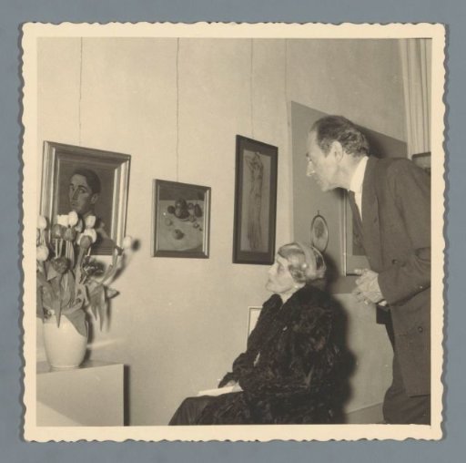 Visitors viewing paintings at a posthumous exhibition of Han van der Kop (presumably) in Schoonhoven