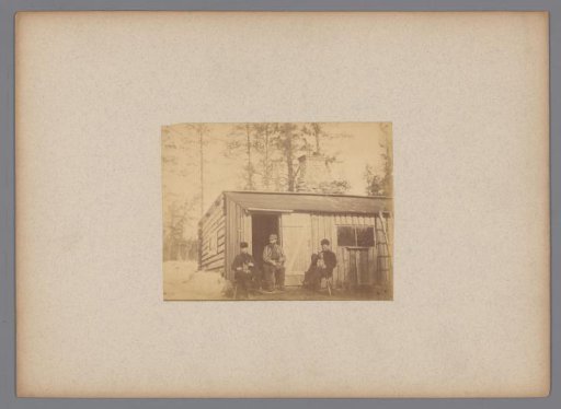 Three men each with a dog on their lap in front of a house in Sweden