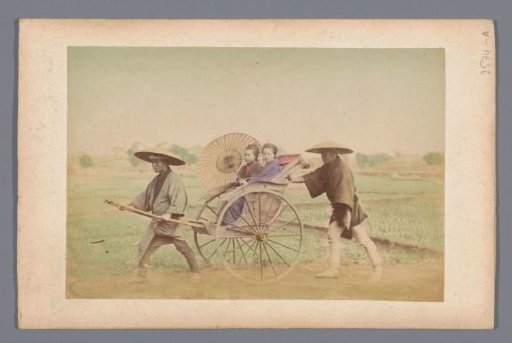 Two young Japanese women in a rickshaw pulled and pushed by two men