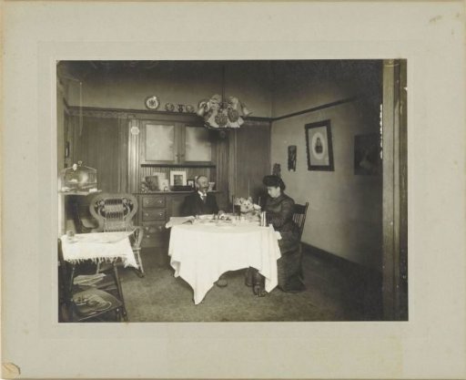 Man and woman with dog at table in interior in Los Angeles