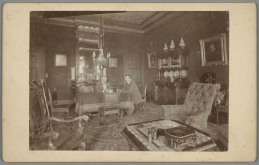 Interior of a house with two men at table
