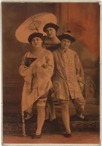 Theatre group portrait of three unknown women in Oriental costumes with parasol