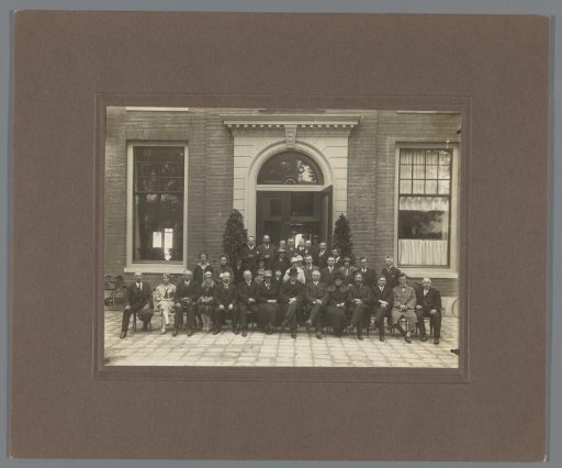 Group portrait of men and women in front of a building entrance