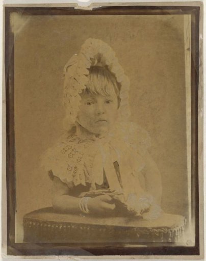 Studio portrait of a toddler with doll and cap