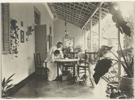 Unknown couple writing on a veranda in Dutch East Indies