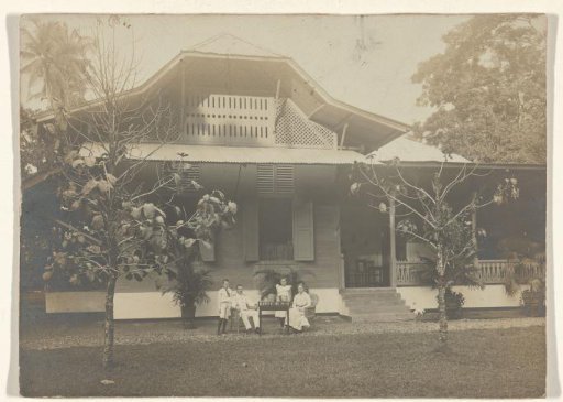 Group portrait of an unknown family in the garden in front of a house, Dutch East Indies