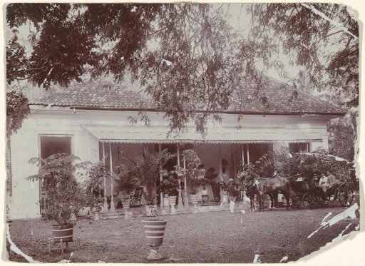 Portrait of an unknown young couple in a carriage, with servants, in front of a house in the Dutch East Indies