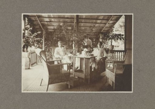 Portrait of an unknown married couple and a servant on a veranda in the Dutch East Indies