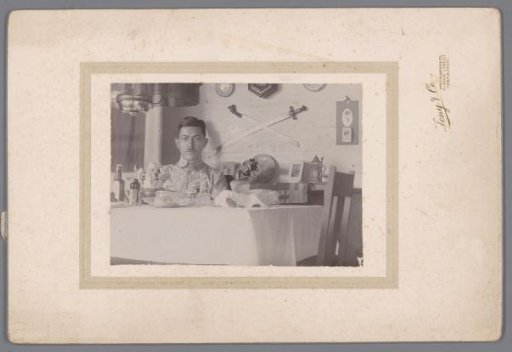 Portrait of an unknown man behind a table